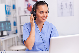 A health care professional works at a computer