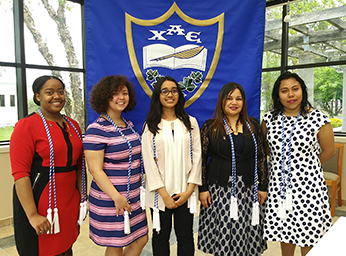 Students standing in front of a club banner