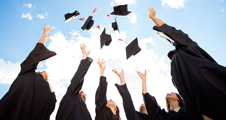 Graduates tossing mortar boards