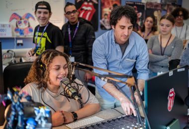 A high school student takes her turn at the college radio microphone