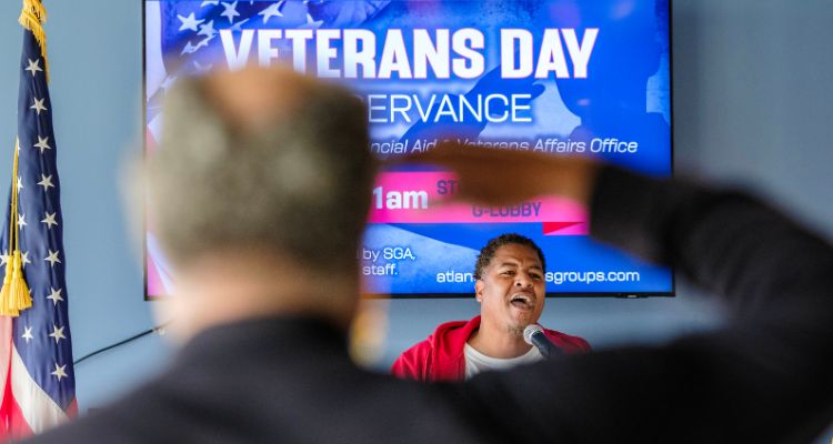 Atlantic Cape's Rashawn Martin sings the national anthem while a vet salutes the flag