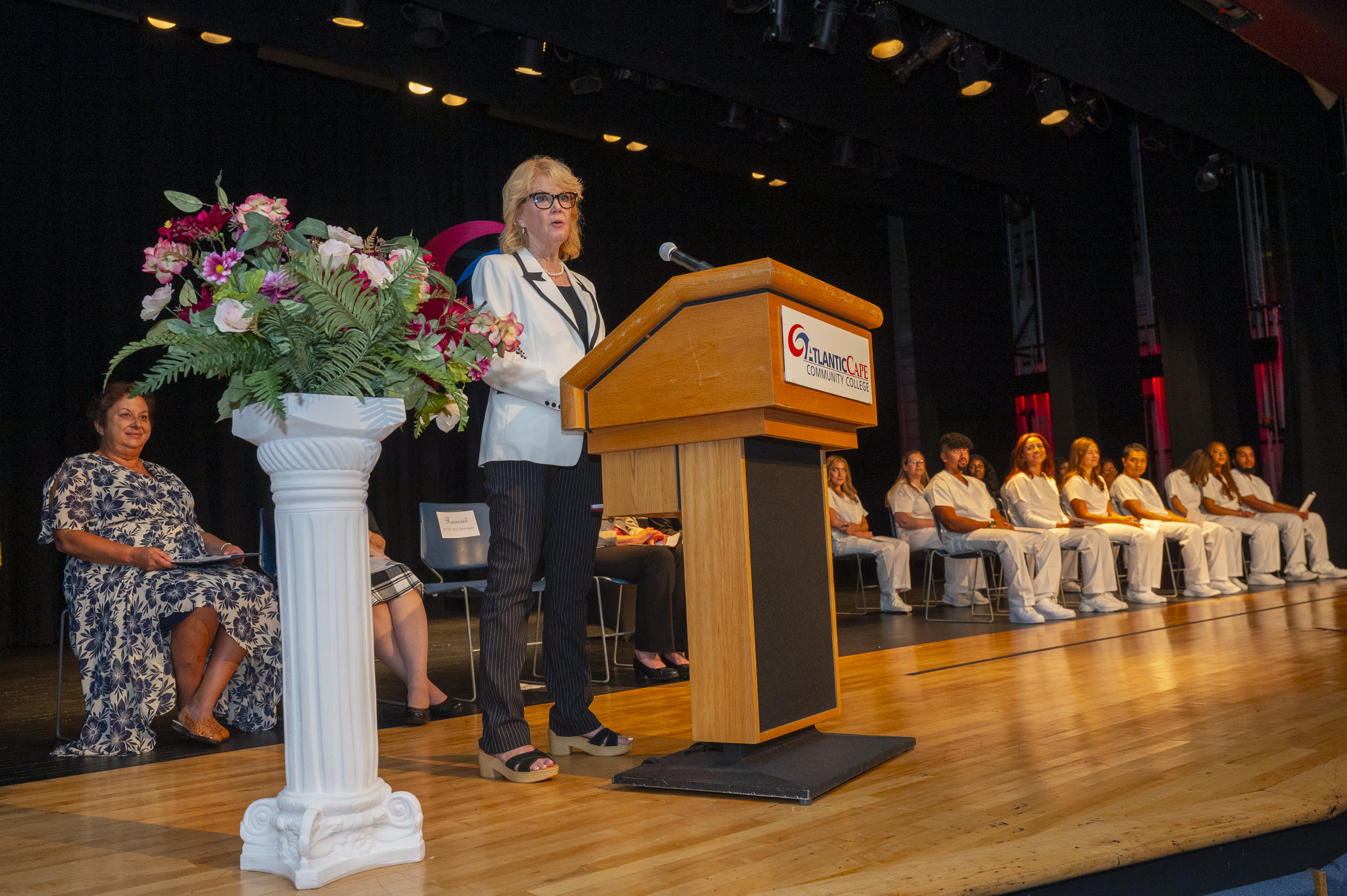 Dr Nina Brannigan addresses the crowd with graduates in background